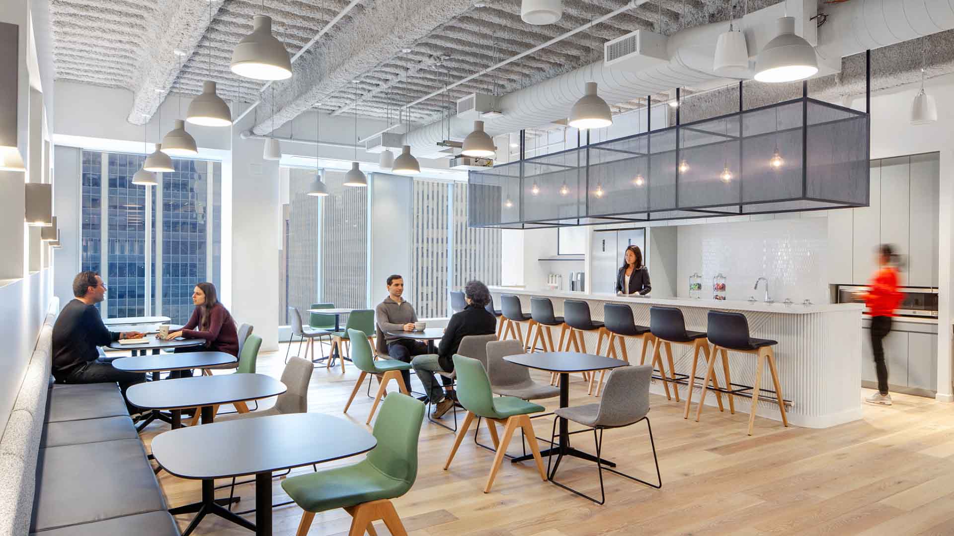 A group of people sitting at tables in an office.